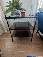 Front view of the wood Baker table showing three levels and gilded accents on the legs and corners.