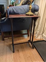 Side view showing the slender turned legs and stretcher bar connecting them.