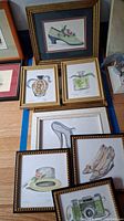 Framed collection of 8 vintage-themed art prints including shoes, perfume bottles, hat, and camera.