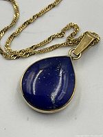 Close-up of pendant showing deep blue lapis lazuli stone and gold bezel