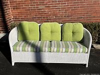 Front view of white wicker couch with green cushions