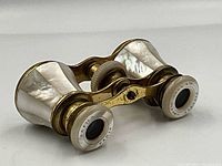 Front perspective view showing mother-of-pearl inlay on barrels and white eyepiece rims with markings.