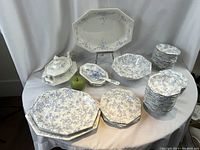 Full lot overview on draped table showing all platters, bowls, saucers, tureen and server