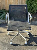 Front view of the black mesh seat and polished aluminum frame on five-star base with casters.