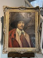 Full view of oil painting in gilded frame leaning on easel