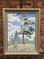Full view of oil painting of redwood tree in ornate frame, brick background
