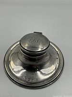 Top view of the sterling silver ink well showing the hinged lid and engraved initials on the lid.