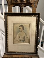 Full view of the framed watercolour depicting a young woman titled "Lady Carew". The frame is dark wood with decorative molding. The mat is wide and cream colored with some age spotting.