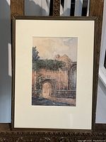 Full view of the framed watercolour painting depicting an architectural scene with an archway and brick walls.