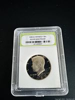 Obverse side of the 1980-S Kennedy half dollar DCAM gem proof coin showing John's profile and date in a sealed clear plastic case with certification label.