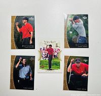 Five Tiger Woods cards from the 2001 Upper Deck Stat Leaders series spread on white background, showing various golf poses and celebration moments.