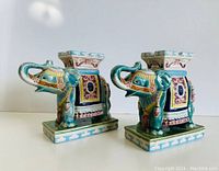 Pair of Majolica elephant stands side by side on white surface