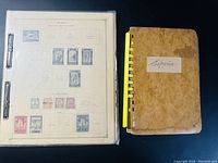 Top view of a binder containing album pages of Spain stamps and a separate brown spiral-bound stock book labeled 'España'.