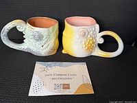 Two ceramic espresso cups shaped like lizards with detailed scales, displayed side-by-side.