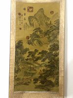 Full view of vertical silk painting depicting mountain landscape and decorative border