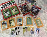 Photo showing assorted vintage baseball cards including individual player cards and Baseball's All-Time Greats collector's set with Henry Aaron and Mickey Mantle on cover.