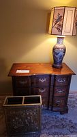 Wooden dresser with porcelain lamp on top and brass umbrella stand in front, showing overall lot contents.