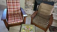 Two mission style chairs and one embroidered stool arranged in living room area near fireplace.