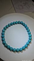 Natural robin's egg blue turquoise bead stretchy bracelet on a white surface, beads approximately 6mm diameter.