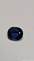 Close-up image of the natural royal blue Ceylon sapphire loose gemstone showing the deep blue color and faceting.