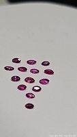 Focus on marquis cut rubies varying slightly in size and color under natural light, against a white background.