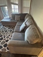 Angled view of gray L-shaped sectional sofa showing chaise and seating area