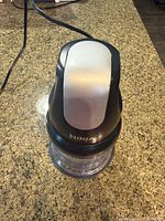 Top view of Ninja vegetable mixer showing silver push-button and black body