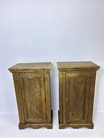 Frontal view of the brass wrapped cabinets showing the etched floral patterns and oxidation spots.