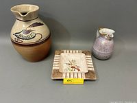 Photo of the two pitchers and ash tray on a surface