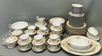 Full set arranged showing all types of pieces including stacked plates, cups with saucers, serving platters and specialty dishes