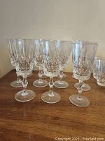 Photo of several tall Cross and Olive crystal stemmed wine glasses with detailed cut pattern, arranged in two rows.