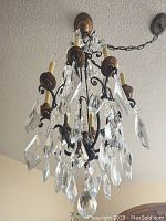 Chandelier viewed from below showing crystals and scrolling arms