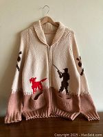 Full front view of beige and taupe wool knit zip-front cardigan with hunting motif designs in orangey-red and dark brown.