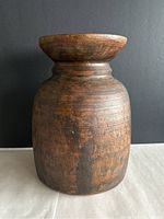 Front view of carved wooden vase showing wood texture and finish