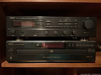 Front view of Denon DMA-520R receiver stacked above DCM-380 CD changer, showing control buttons, display, and branding