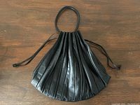 Full front view showing fan-shaped pleated design and strap