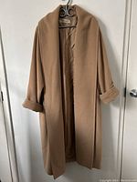 Full front view of camel coat hanging on a door