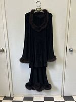 Front view of the full two-piece outfit hanging, showing the knit top and skirt with mink fur trim on neckline, cuffs, and skirt hem.