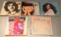 Photo of 5 vintage LP records featuring Joe Cocker, Cher, Donna Summer, and Chicago albums, laid out on a grey surface.