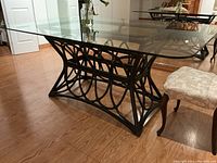 Side angle showing bamboo base construction and glass top with reflection.