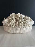 Front view showing the cream crackled glaze ceramic vegetable basket bowl with detailed vegetable sculpting on the lid.