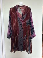 Front view of vintage Uru dress showing burgundy silk velvet with abstract patterns and plum tie-dye semi-sheer sleeves, button front visible with one button missing near bottom, pockets noticeable.