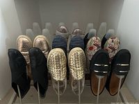 Overview photo of 8 pairs of women's size 9 shoes placed on a rack