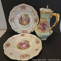 Photo showing Limoges chocolate pot with hand-painted florals, gold handle, spout, and finial. Two Winterling Bavaria plates with romantic pictorial scenes also visible.