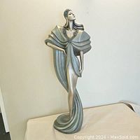 Front full view of the Art Deco sculpture showing stylized female figure in flowing geometric garment.