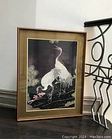 Full view of the vintage framed print showing two white cranes with red crowns standing among stylized bushes on a dark background.