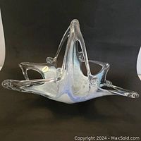 Side angle of triangular Murano glass basket showing opalescent pastel swirl pattern and three elongated points with rounded ends.