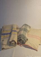 Three wool blankets folded and displayed with visible color and pattern differences.