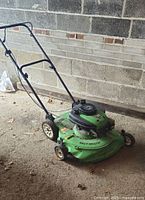 Full side view of the green Yardworks Easy Mulch lawnmower with branding visible on the deck and wheels.