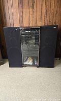 Full view of the entire Pioneer stereo stack system with two large speakers on either side, in wood panel room.